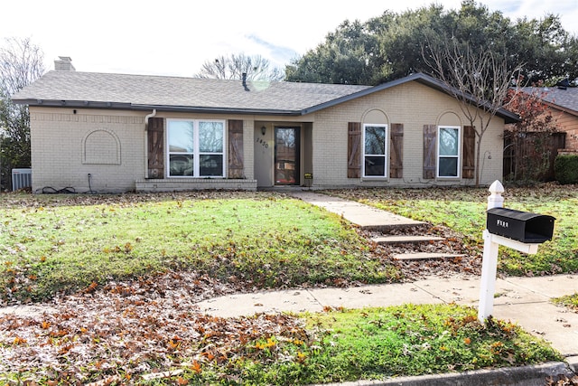 ranch-style home featuring brick siding, a front lawn, central AC unit, and a chimney