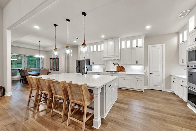308 Secretariat, Hickory Creek, TX 75065 - kitchen featuring appliances with stainless steel finishes, light countertops, recessed lighting, light wood finished floors, and a kitchen island with sink