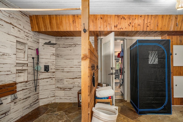 4151 Oakcrest Ln, Fort Worth, TX 76126 - bathroom featuring tiled shower, stone finish flooring, and wooden walls