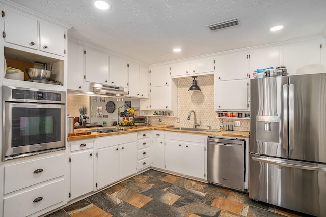 4151 Oakcrest Ln, Fort Worth, TX 76126 - kitchen with appliances with stainless steel finishes, a sink, dark stone finish flooring, white cabinetry, and under cabinet range hood