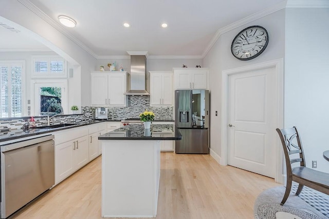 513 Suncreek Dr, Allen, TX 75013 - kitchen with appliances with stainless steel finishes, wall chimney exhaust hood, a sink, light wood-style floors, and ornamental molding