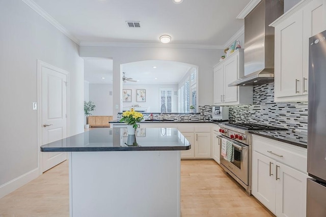 513 Suncreek Dr, Allen, TX 75013 - kitchen featuring appliances with stainless steel finishes, wall chimney exhaust hood, dark countertops, a center island, and backsplash