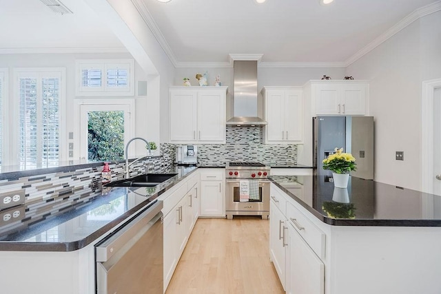 513 Suncreek Dr, Allen, TX 75013 - kitchen with stainless steel appliances, a sink, wall chimney range hood, white cabinets, and ornamental molding