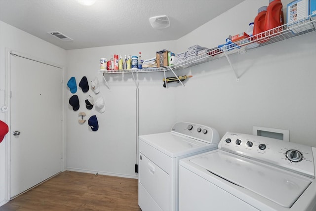 10748 Irish Glen Trl, Fort Worth, TX 76052 - laundry area featuring washing machine and dryer, wood finished floors, and a textured ceiling