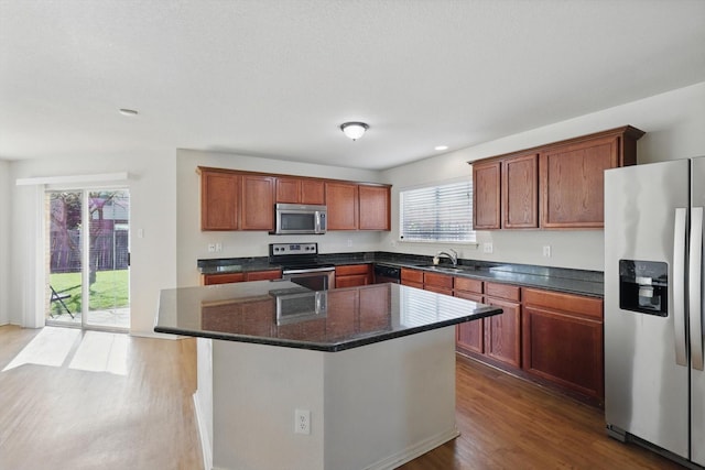10748 Irish Glen Trl, Fort Worth, TX 76052 - kitchen featuring stainless steel appliances, dark wood-style flooring, a center island, recessed lighting, and a sink