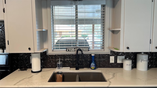 501 Linda Kay Dr, Winnsboro, TX 75494 - kitchen with a sink, backsplash, white cabinetry, and light stone counters