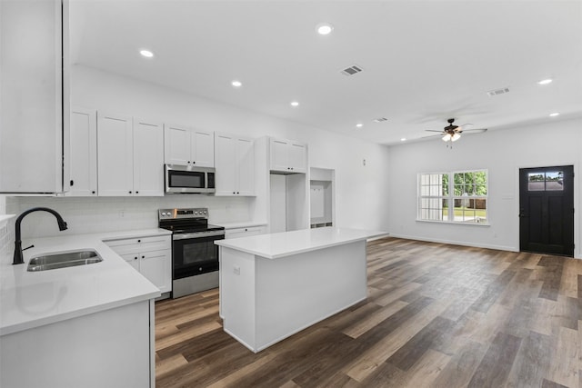 1612 Cheyenne Trl, Granbury, TX 76048 - kitchen featuring stainless steel appliances, a sink, white cabinets, a ceiling fan, and backsplash