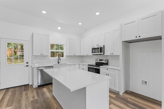 1612 Cheyenne Trl, Granbury, TX 76048 - kitchen with appliances with stainless steel finishes, a sink, wood finished floors, backsplash, and white cabinetry