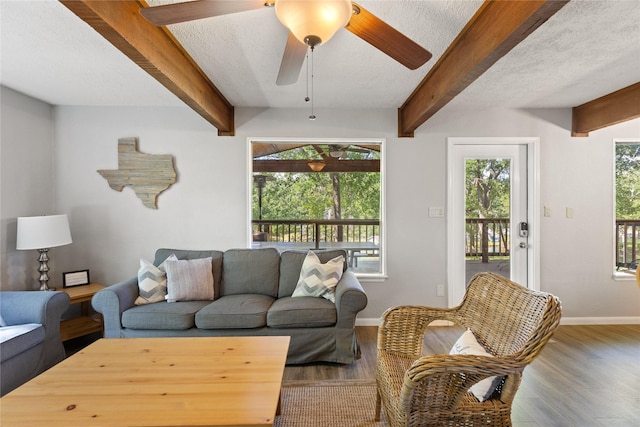 107 Nob Hill Cir, Malakoff, TX 75148 - living room with baseboards, beamed ceiling, wood finished floors, ceiling fan, and a textured ceiling