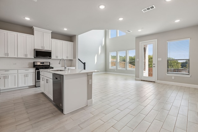 2929 Galveston St, Plano, TX 75075 - kitchen with stainless steel appliances, a sink, open floor plan, decorative backsplash, and light countertops