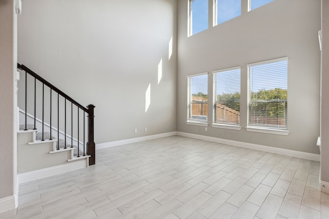 2929 Galveston St, Plano, TX 75075 - unfurnished living room featuring a high ceiling, baseboards, stairs, and wood finished floors