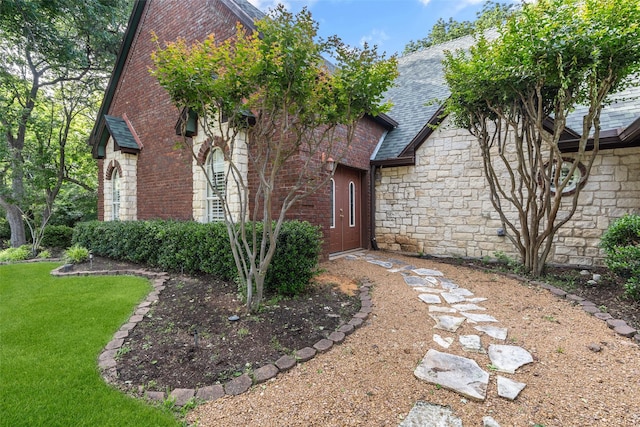1201 Tralee Ln, Garland, TX 75044 - view of front of property featuring stone siding, a front lawn, a shingled roof, and brick siding