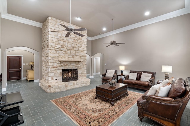 1201 Tralee Ln, Garland, TX 75044 - living room with arched walkways, ceiling fan, crown molding, a stone fireplace, and a high ceiling