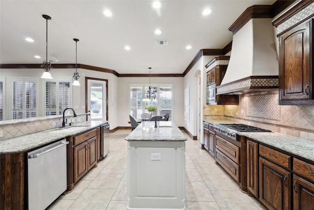 3316 Fairway Dr, Denton, TX 76226 - kitchen featuring appliances with stainless steel finishes, an island with sink, a sink, tasteful backsplash, and premium range hood