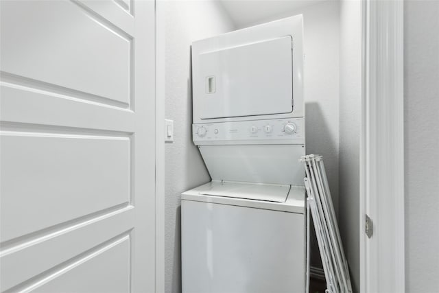 5816 Grayson St, Fort Worth, TX 76119 - clothes washing area featuring estacked washer and dryer and a textured wall