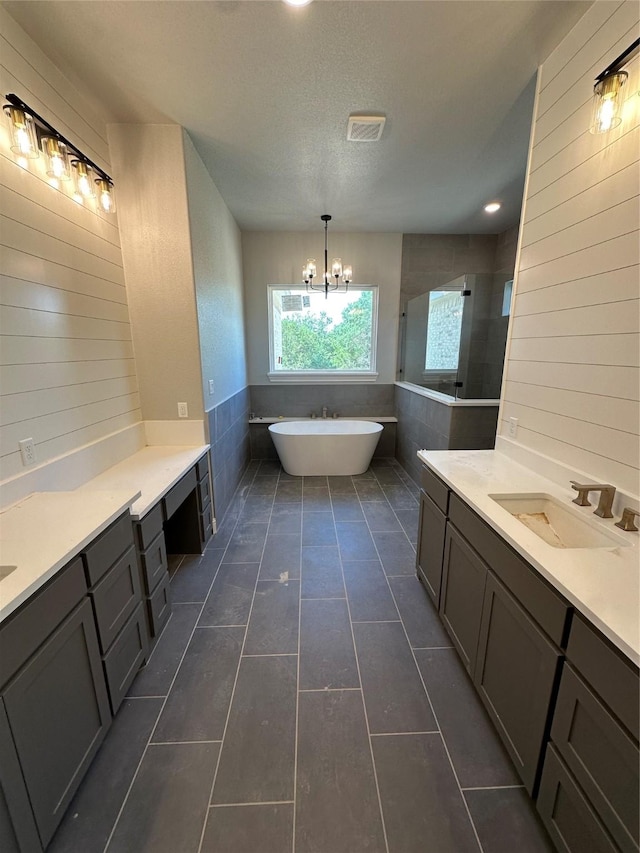 544 Aermotor Loop, Weatherford, TX 76085 - full bath featuring a freestanding bath, a chandelier, tile patterned floors, two vanities, and a textured ceiling