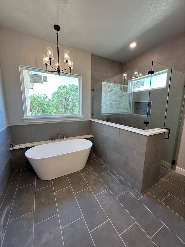 544 Aermotor Loop, Weatherford, TX 76085 - full bath with plenty of natural light, a shower stall, a freestanding bath, tile walls, and a textured ceiling