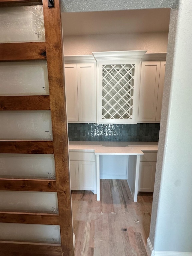 544 Aermotor Loop, Weatherford, TX 76085 - bar with light wood-style floors, built in study area, and decorative backsplash