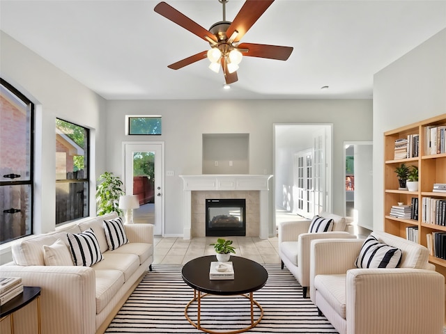 6400 Hawthorn Dr, Denton, TX 76208 - living room featuring a ceiling fan, a fireplace, light tile patterned flooring, and baseboards
