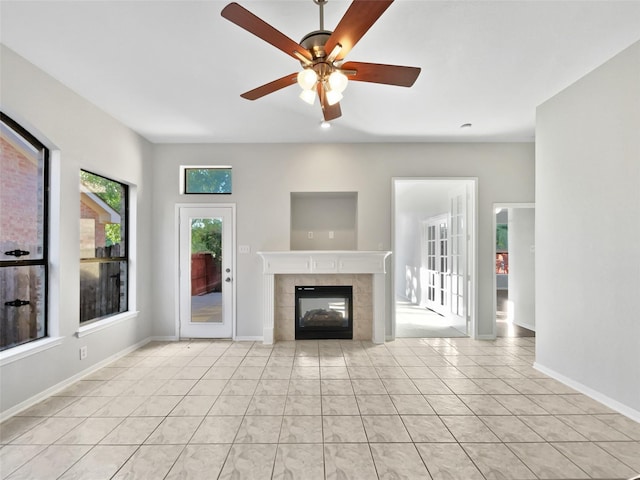 6400 Hawthorn Dr, Denton, TX 76208 - unfurnished living room featuring ceiling fan, a tiled fireplace, and baseboards