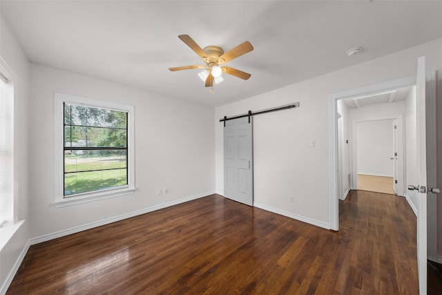 2320 Herring Ave, Waco, TX 76708 - unfurnished bedroom with wood finished floors, baseboards, ceiling fan, and a barn door