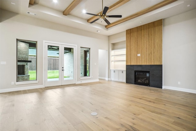 3621 Barber Crk, Fort Worth, TX 76244 - unfurnished living room with a large fireplace, french doors, light wood finished floors, a ceiling fan, and beam ceiling