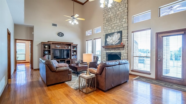 1905 Yucatan Dr, Granbury, TX 76048 - living area with ceiling fan, a towering ceiling, a fireplace, light wood finished floors, and baseboards