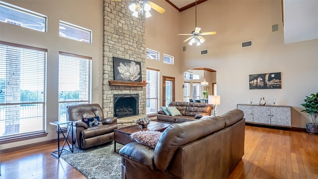 1905 Yucatan Dr, Granbury, TX 76048 - living room featuring ceiling fan, hardwood / wood-style flooring, a high ceiling, arched walkways, and a fireplace