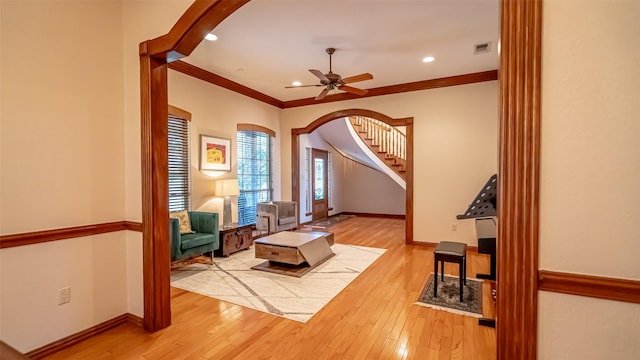 1905 Yucatan Dr, Granbury, TX 76048 - living area with arched walkways, wood finished floors, stairs, crown molding, and a ceiling fan