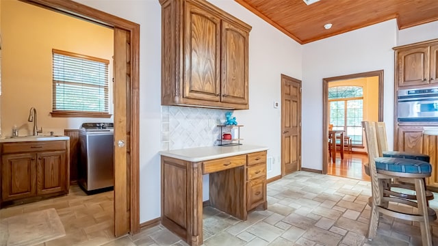 1905 Yucatan Dr, Granbury, TX 76048 - kitchen featuring washer / dryer, a sink, oven, backsplash, and light countertops