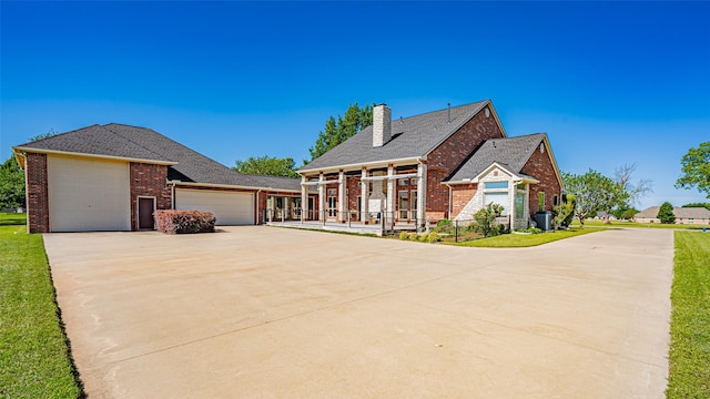 1905 Yucatan Dr, Granbury, TX 76048 - greek revival house with brick siding, an attached garage, driveway, a chimney, and a front lawn