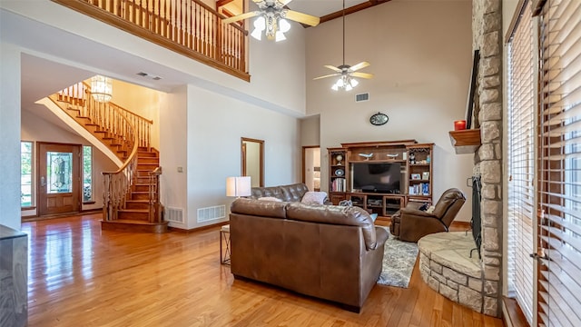 1905 Yucatan Dr, Granbury, TX 76048 - living room with ceiling fan, a towering ceiling, wood finished floors, stairs, and baseboards