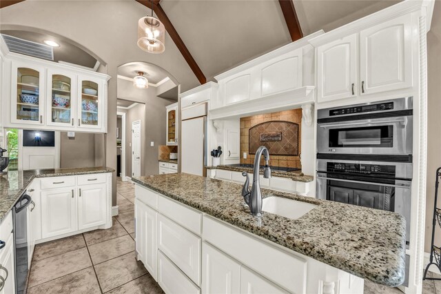 124 Oakvista Dr, Aledo, TX 76008 - kitchen with double oven, arched walkways, glass insert cabinets, high vaulted ceiling, and white cabinets