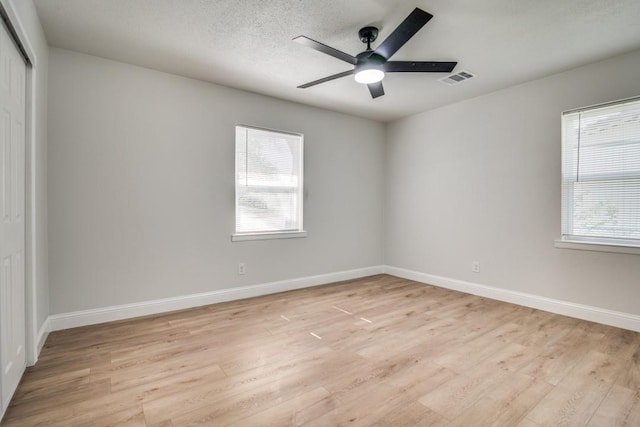 unfurnished bedroom featuring multiple windows and light wood-type flooring