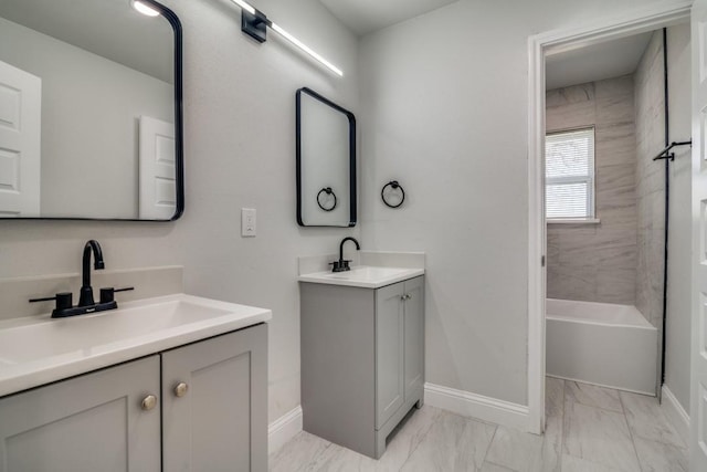 bathroom featuring baseboards, two vanities, and marble finish flooring