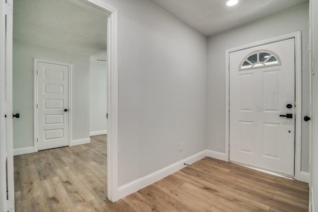 foyer with light wood-style floors, baseboards, and recessed lighting