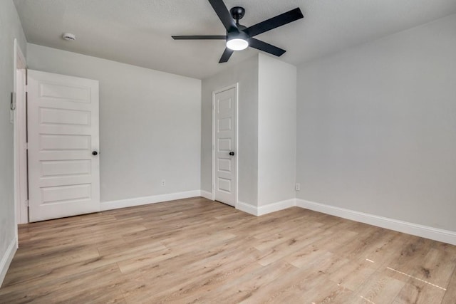 unfurnished bedroom featuring light wood-style flooring, baseboards, and ceiling fan