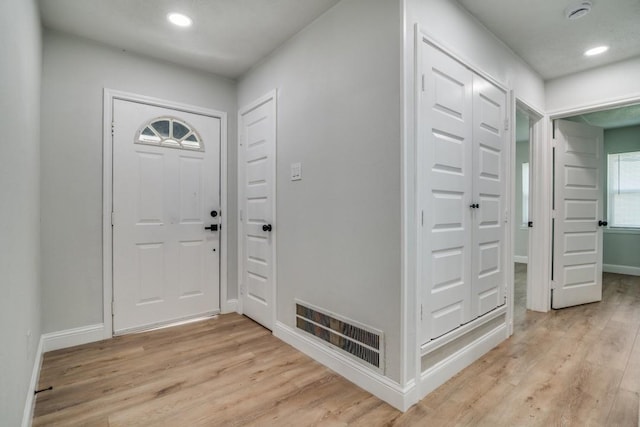 foyer with light wood-style floors, baseboards, and recessed lighting