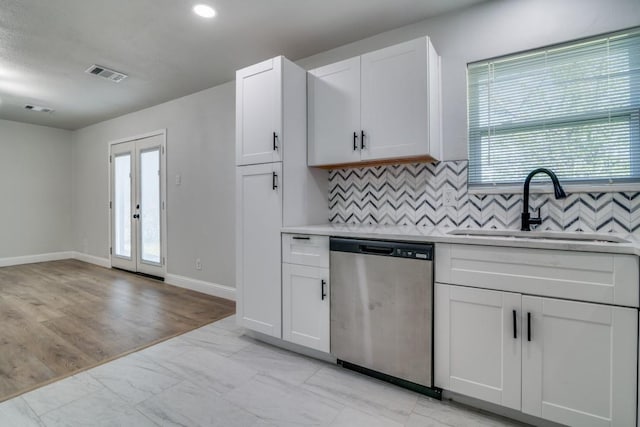 kitchen with stainless steel dishwasher, a sink, decorative backsplash, plenty of natural light, and recessed lighting