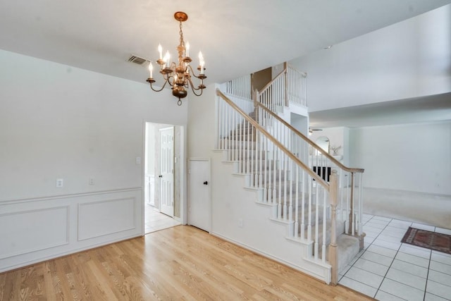 4136 Timberglen Rd, Dallas, TX 75287 - stairs featuring a chandelier, wood finished floors, and a towering ceiling