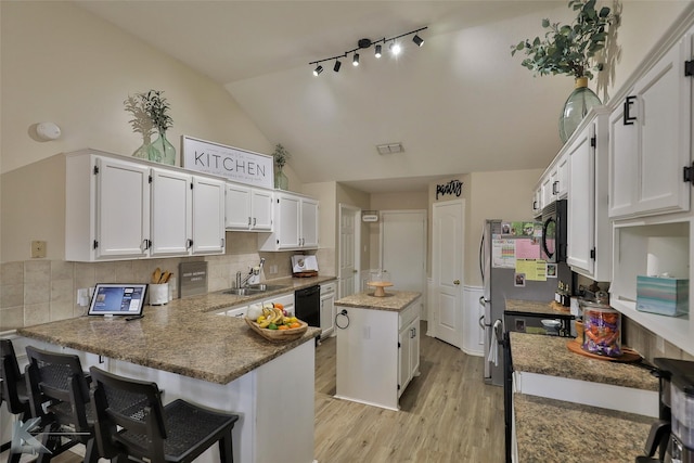 5249 Western Plains Ave, Abilene, TX 79606 - kitchen with black appliances, white cabinets, light wood-type flooring, tasteful backsplash, and high vaulted ceiling