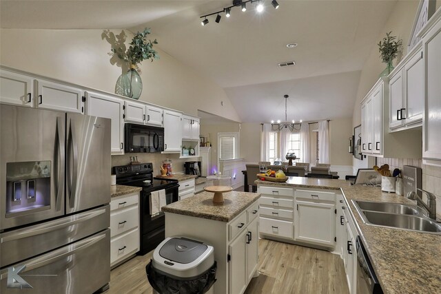 5249 Western Plains Ave, Abilene, TX 79606 - kitchen featuring black appliances, vaulted ceiling, a sink, and white cabinetry