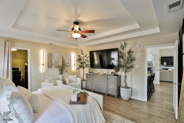 5249 Western Plains Ave, Abilene, TX 79606 - bedroom featuring a tray ceiling, light wood-style floors, baseboards, and ceiling fan