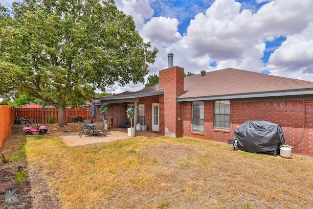 5249 Western Plains Ave, Abilene, TX 79606 - back of property with brick siding, a chimney, a patio area, and a shingled roof