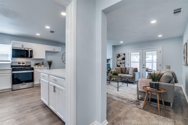 2335 San Paula Ave, Dallas, TX 75228 - kitchen featuring stainless steel appliances, french doors, white cabinets, light wood-style floors, and light countertops