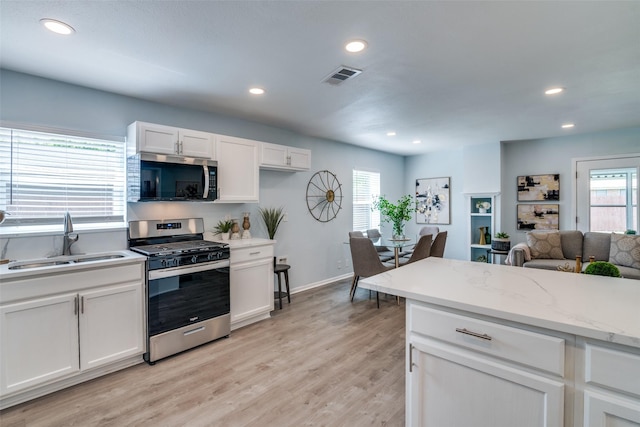2335 San Paula Ave, Dallas, TX 75228 - kitchen featuring stainless steel appliances, a sink, white cabinetry, healthy amount of natural light, and recessed lighting