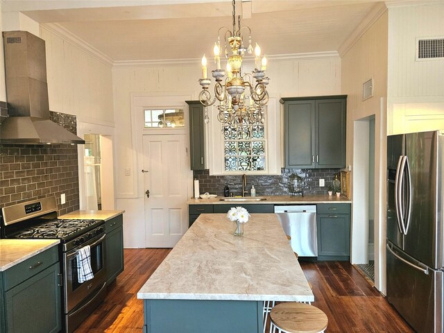 301 W Larissa St, Jacksonville, TX 75766 - kitchen featuring appliances with stainless steel finishes, a sink, wall chimney range hood, dark wood-style flooring, and crown molding