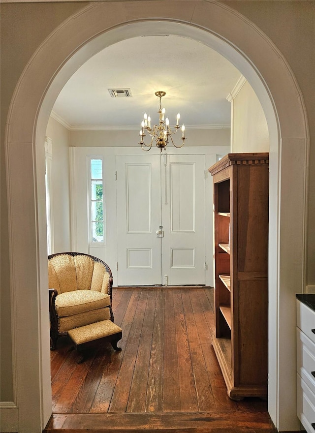 301 W Larissa St, Jacksonville, TX 75766 - living area featuring arched walkways, dark wood finished floors, ornamental molding, and a chandelier