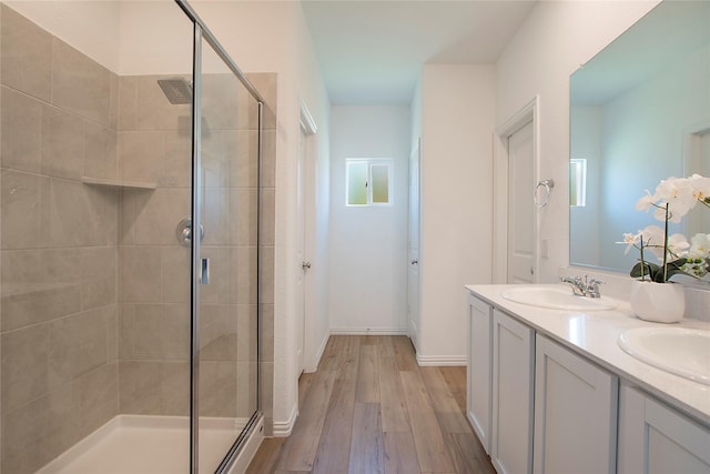 2560 Eden Creek Dr, Fort Worth, TX 76179 - bathroom with a shower stall, wood finished floors, double vanity, and baseboards