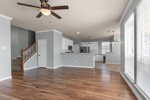 4504 Angelina Way, Fort Worth, TX 76137 - unfurnished living room with a chandelier, a ceiling fan, dark wood-type flooring, baseboards, and crown molding
